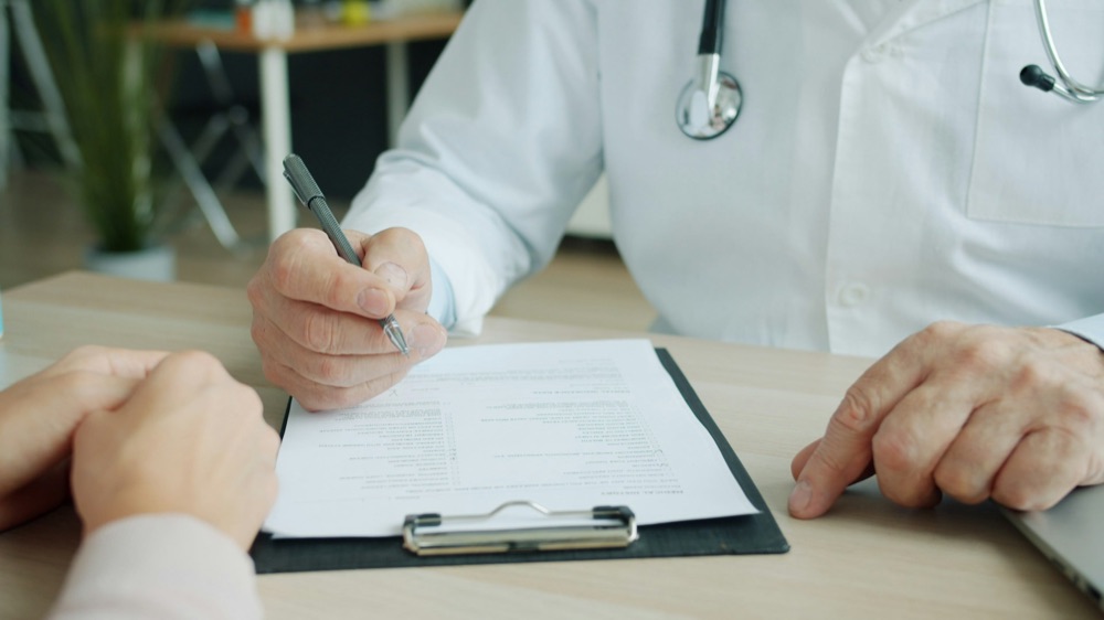 Médecin remplissant un dossier patient